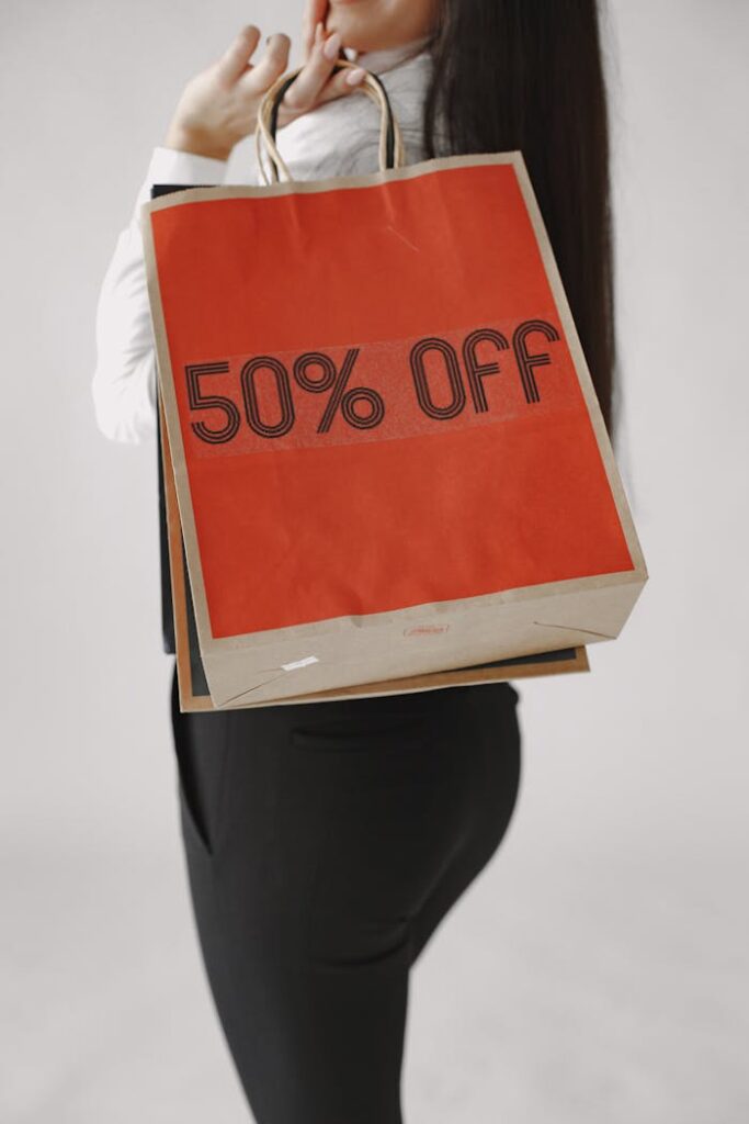 Close-up of a woman holding a shopping bag with a 50% off sale offer.